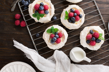 Fresh granola, muesli with berries, honey in a glass jars on a white wooden background, selective focus