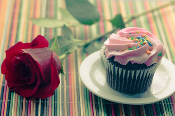 Pink cupcake with red rose.