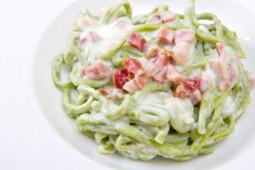 green spaghetti pasta with bacon and cream
