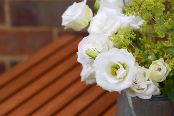 White tulip gentians with ladys mantle on a wooden table