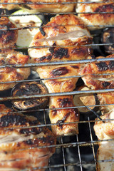 Chicken legs and zucchini on grill grate