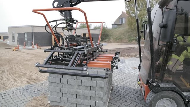 Detail of paving machine picking up stones to be laid out.