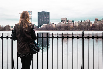 Fototapeta na wymiar Girl on a fence at Central Park in Manhattan, New York City