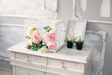 dresser with flowers in a light classical interior - obrazy, fototapety, plakaty