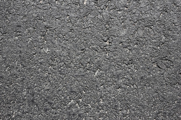 Black rough grainy asphalt background.