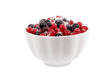 Black and red currants with sugar in a white cup. Object on a white background
