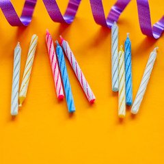 Fototapeta premium Candles and streamer on yellow background. Preparing for a birthday
