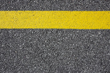 Yellow paint line on asphalt background.