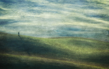 Abstract image of person walking on rolling landscape