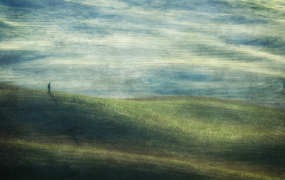 Abstract Image Of Person Walking On Rolling Landscape