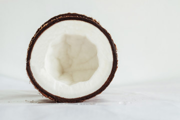 Cross section of coconut half on a soft white glossy surface