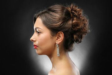 Young beautiful woman with nice hairdo on dark background