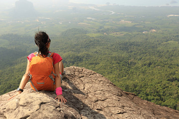 Obraz premium young asian woman hiker enjoy the view on mountain peak cliff
