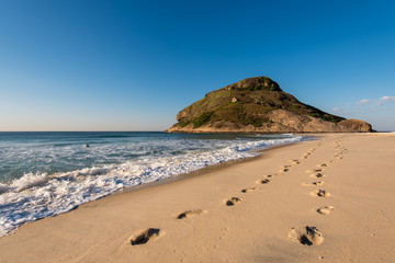 Footsteps in Sand in Recreio Beach and Pontal Rock in the Ocean