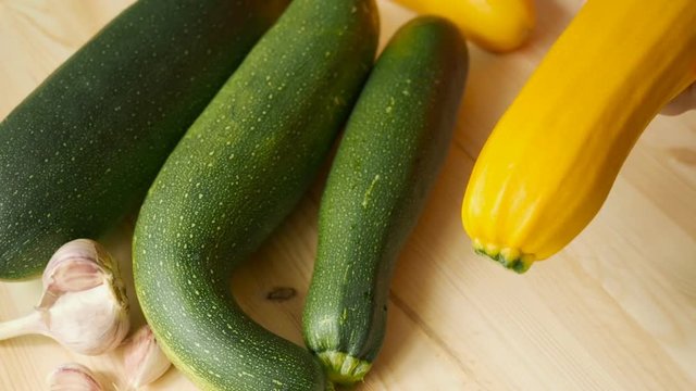 Woman hands cleaning the kitchen knife yellow zucchini