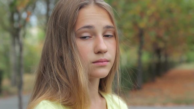 Pensive sad face portrait teen girl in autumn park