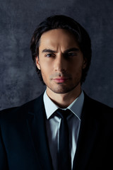 Portrait of handsome harsh hispanic man on gray background