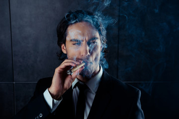 Closeup portrait of brutal young man  smoking a cigar