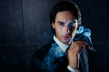 Closeup portrait of brutal handsome man  holding a cigar with sm