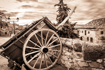 Fototapeta na wymiar monochrome of an old chariot used for decoration and an ancient village