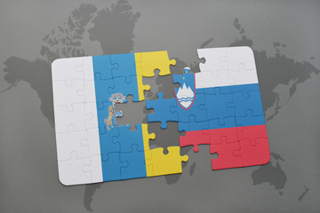 puzzle with the national flag of canary islands and slovenia on a world map background.