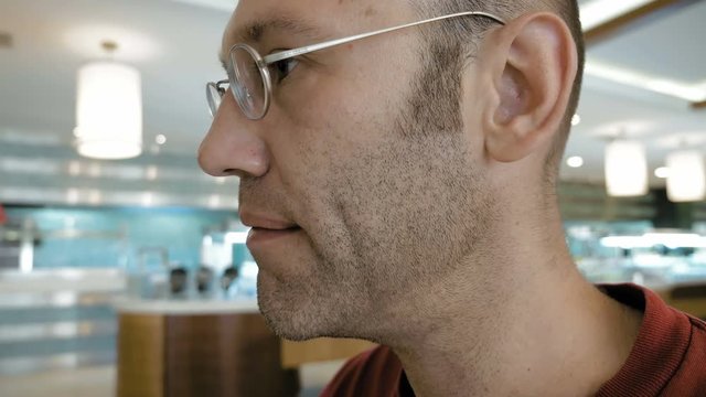 A man is enjoying his morning cup-o-joe in a public place. Coffee can be enjoyed anywhere anytime and is viable in various flavors. Most people drink black coffee.