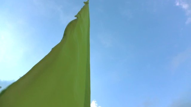 Slow motion of green fabric flag waving with the wind
