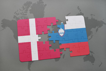 puzzle with the national flag of denmark and slovenia on a world map background.