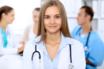 Happy doctor woman  with medical staff at the hospital sitting at the table and discussing medical history