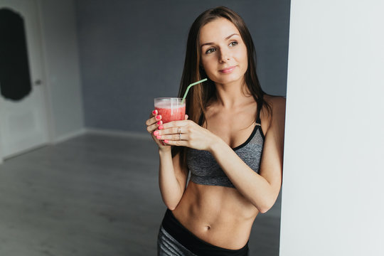 Sexual sports girl drinks smoothie and relaxing after training fitness