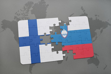 puzzle with the national flag of finland and slovenia on a world map background.