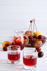 Iced fruit compote with peaches and plums. Cold summer drink.