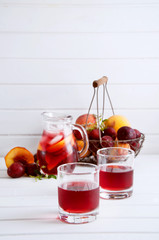 Iced fruit compote with peaches and plums. Cold summer drink.