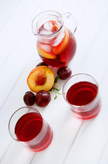 Iced fruit compote with peaches and plums. Cold summer drink.