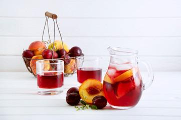 Iced fruit compote with peaches and plums. Cold summer drink.