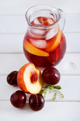 Iced fruit compote with peaches and plums. Cold summer drink.