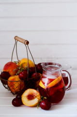 Iced fruit compote with peaches and plums. Cold summer drink.