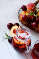 Iced fruit compote with peaches and plums. Cold summer drink.