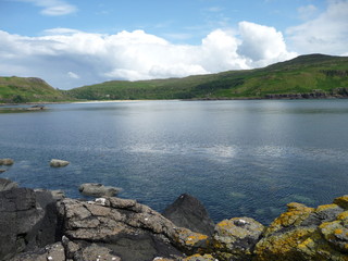 View across Calgary Bay, Isle of Mull, Scotland with clouds reflected in the calm blue waters of the Bay