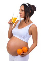 Pregnancy and vitamins. Pregnant woman and oranges and fresh juice. Isolated on white background