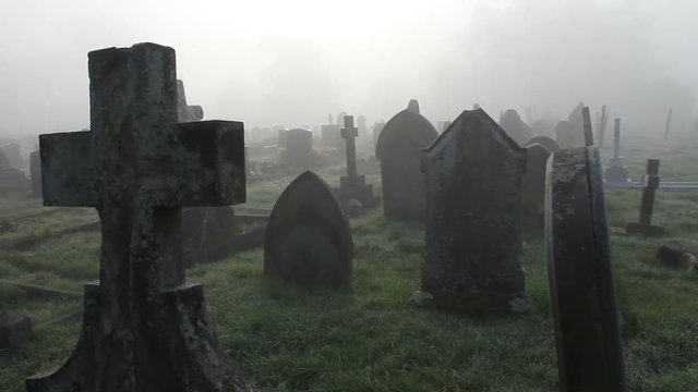 Spooky graveyard in the grounds of an old Chapel. Shot in early morning in deep mist / fog for an extra spooky feel.