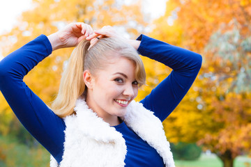 Young woman spend time in autumnal park.