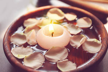 Petals in bowl with candle, closeup