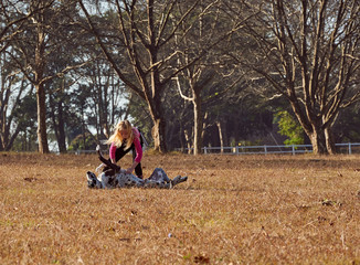Girl and her dog running playing in  open field