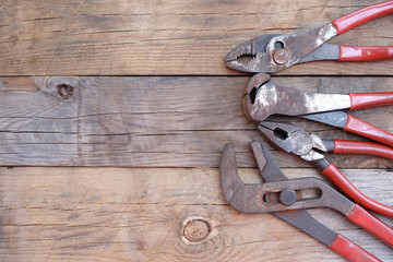 pliers set red handle over a wood panel. Top view with copy space.