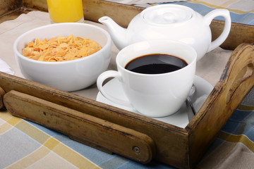 Breakfast tray with coffee, orange juice and cereals.