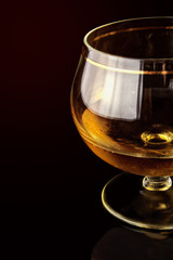 Shot glass with alcohol against a dark background.
