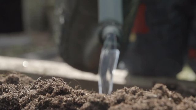 Closeup shot of a watering can watering newly composted soil