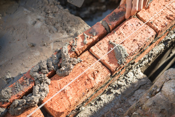 plasterer making up a brick wall with cement