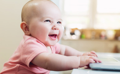 Happy baby girl using laptop computer